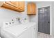 Well-lit laundry room with a modern washer and dryer set and gray door at 901 Vicksburg St, Deltona, FL 32725
