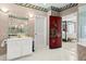 Bathroom vanity with stylish mirror and a red door leading to a bedroom with canopy bed at 915 Ocean Shore Blvd # 8010, Ormond Beach, FL 32176