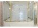 Bright bathroom featuring a soaking tub enclosed by a glass shower with gold trim at 915 Ocean Shore Blvd # 8010, Ormond Beach, FL 32176