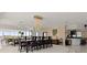 Open-concept dining area with a long dining table and chairs is illuminated by a stunning chandelier at 915 Ocean Shore Blvd # 8010, Ormond Beach, FL 32176