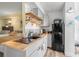 Compact kitchenette featuring modern appliances, butcher block countertops, and open shelving for storage at 935 S Atlantic Ave # 511, Daytona Beach, FL 32118