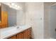 Cozy bathroom with a shower, wooden vanity, and neutral-toned floral wallpaper at 980 Marjorie Rawlings Dr, Deland, FL 32720