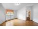 Well-lit bedroom featuring hardwood floors, white walls and a large window with window treatment at 980 Marjorie Rawlings Dr, Deland, FL 32720
