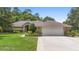 Charming single-story home with a well-manicured lawn, brick facade, and attached two-car garage at 980 Marjorie Rawlings Dr, Deland, FL 32720