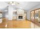 Bright living room features a brick fireplace, wood floors, and doors to the outside at 980 Marjorie Rawlings Dr, Deland, FL 32720