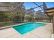 Backyard pool and spa with an enclosed screen and garden views at 980 Marjorie Rawlings Dr, Deland, FL 32720