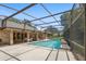 Backyard pool is enclosed and features brick design on home's rear facade at 980 Marjorie Rawlings Dr, Deland, FL 32720