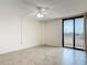 Bedroom boasts neutral tile flooring, a ceiling fan, and sliding door access to balcony at 1 Oceans West Blvd # 2A1, Daytona Beach, FL 32118