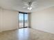 Bedroom features neutral tile flooring, a ceiling fan, and sliding door access to balcony at 1 Oceans West Blvd # 2A1, Daytona Beach, FL 32118