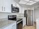 Bright kitchen featuring stainless steel appliances, modern white cabinetry and granite counters at 1 Oceans West Blvd # 2A1, Daytona Beach, FL 32118