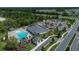 Aerial view of a community pool, clubhouse, and manicured landscaping at 1000 Megano Blvd, Deland, FL 32724