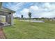 Manicured lawn and landscaping enhance the backyard, complete with a scenic pond view at 1000 Megano Blvd, Deland, FL 32724