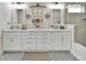 Elegant bathroom with a double vanity, decorative mirrors, lighting fixtures, and a seamless glass shower at 1000 Megano Blvd, Deland, FL 32724