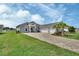 New construction home boasts a three-car garage, manicured lawn and paved driveway at 1000 Megano Blvd, Deland, FL 32724