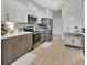 Bright kitchen with stainless steel appliances, light wood flooring, and modern white and brown cabinets at 1000 Megano Blvd, Deland, FL 32724