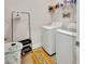 Functional laundry room equipped with a washer, dryer, storage rack, and laundry accessories at 1000 Megano Blvd, Deland, FL 32724