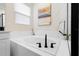 Close-up of a modern bathtub and stylish black matte fixtures and hardware at 1002 River Falls Cir, Deland, FL 32720