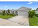 Street view of a well-maintained one-story home, featuring manicured landscaping and a two-car garage at 1002 River Falls Cir, Deland, FL 32720