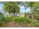 The property's backyard features natural landscaping and a wooden fence at 104 N Park Pl, Edgewater, FL 32132