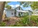 A partial view of the backyard reveals a charming blue house and natural landscaping at 104 N Park Pl, Edgewater, FL 32132