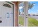 Exterior entryway features a white door with a decorative window and glass storm door at 104 N Park Pl, Edgewater, FL 32132