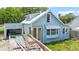 Quaint blue bungalow featuring a bright exterior with a dumpster in the driveway at 104 N Park Pl, Edgewater, FL 32132