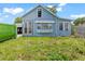 Charming light blue home featuring a metal roof, inviting front porch, and ready for renovation at 104 N Park Pl, Edgewater, FL 32132