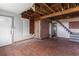 An unfinished living room with exposed framework and hardwood flooring showcases remodeling potential at 104 N Park Pl, Edgewater, FL 32132