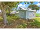 Exterior side view of the light blue home with a metal roof and fenced yard, ready for renovation at 104 N Park Pl, Edgewater, FL 32132