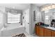 Bright bathroom with a tub, updated vanity, and decorative towel rack at 10800 Crescent Ridge Loop, Clermont, FL 34711