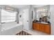 Bright bathroom featuring a tub, white door, and a modern vanity area at 10800 Crescent Ridge Loop, Clermont, FL 34711