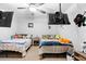 Shared bedroom featuring two beds, ceiling fan and mounted TVs at 10800 Crescent Ridge Loop, Clermont, FL 34711
