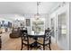 Bright dining area with a modern chandelier and natural light from a glass door leading to the outside at 10800 Crescent Ridge Loop, Clermont, FL 34711