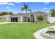 Charming single-story home with a well-manicured lawn, palm tree, and a decorative water feature at 10800 Crescent Ridge Loop, Clermont, FL 34711