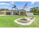 Attractive home featuring a decorative pond, green lawn, and mature landscaping elements at 10800 Crescent Ridge Loop, Clermont, FL 34711