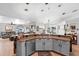 Open kitchen featuring stainless steel appliances, pendant lighting, and a breakfast bar overlooking the living area at 10800 Crescent Ridge Loop, Clermont, FL 34711