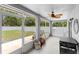 The screened patio includes a grill, a ceiling fan, and a view of the fenced backyard at 10800 Crescent Ridge Loop, Clermont, FL 34711