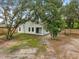 Spacious backyard featuring lush greenery, mature trees, and covered patio, perfect for outdoor living at 1092 Gage Ave, Deltona, FL 32738