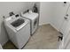 Functional laundry room with modern appliances, tile flooring, and convenient access to the outdoors at 1092 Gage Ave, Deltona, FL 32738