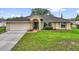 Charming single-story home boasts a vibrant green door, well-manicured lawn, and an attached two-car garage at 1101 Anderson St, Deltona, FL 32725