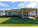 This home features a manicured lawn, a covered patio, and verdant foliage at 112 Chelsea Place Ave, Ormond Beach, FL 32174