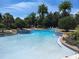 Community pool featuring a water fountain, surrounded by lush landscaping and lounge chairs at 112 Chelsea Place Ave, Ormond Beach, FL 32174