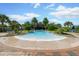 Resort style community pool surrounded by lush palms, landscaping and a brick border at 112 Chelsea Place Ave, Ormond Beach, FL 32174