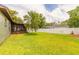 Expansive backyard with lush green lawn, screened porch, palm tree, and white privacy fence at 1166 Tracy Dr, Port Orange, FL 32129