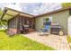 View of the home's backyard with grills, lounge chair, and a screened in sunroom at 1166 Tracy Dr, Port Orange, FL 32129
