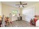 Functional bedroom space with a ceiling fan, closet, wood-look floors, and natural lighting at 1166 Tracy Dr, Port Orange, FL 32129
