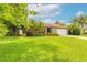 Inviting curb appeal with lush green lawn, mature landscaping, and a charming single story home at 1166 Tracy Dr, Port Orange, FL 32129