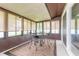 Enclosed sunroom with lots of natural light, table, chairs, and a neutral colored rug at 1166 Tracy Dr, Port Orange, FL 32129