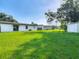 Expansive backyard featuring a lush green lawn, shed, and the exterior of the house at 1203 W 20Th St, Sanford, FL 32771