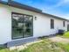 Backyard showcasing a sliding glass door, windows, and lush green grass at 1203 W 20Th St, Sanford, FL 32771